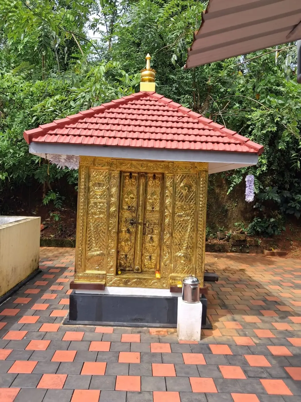 സ്വർണ്ണനിറത്തിലുള്ള വാതിലും ഓടിട്ട മേൽക്കൂരയുമുള്ള സന്നിധി